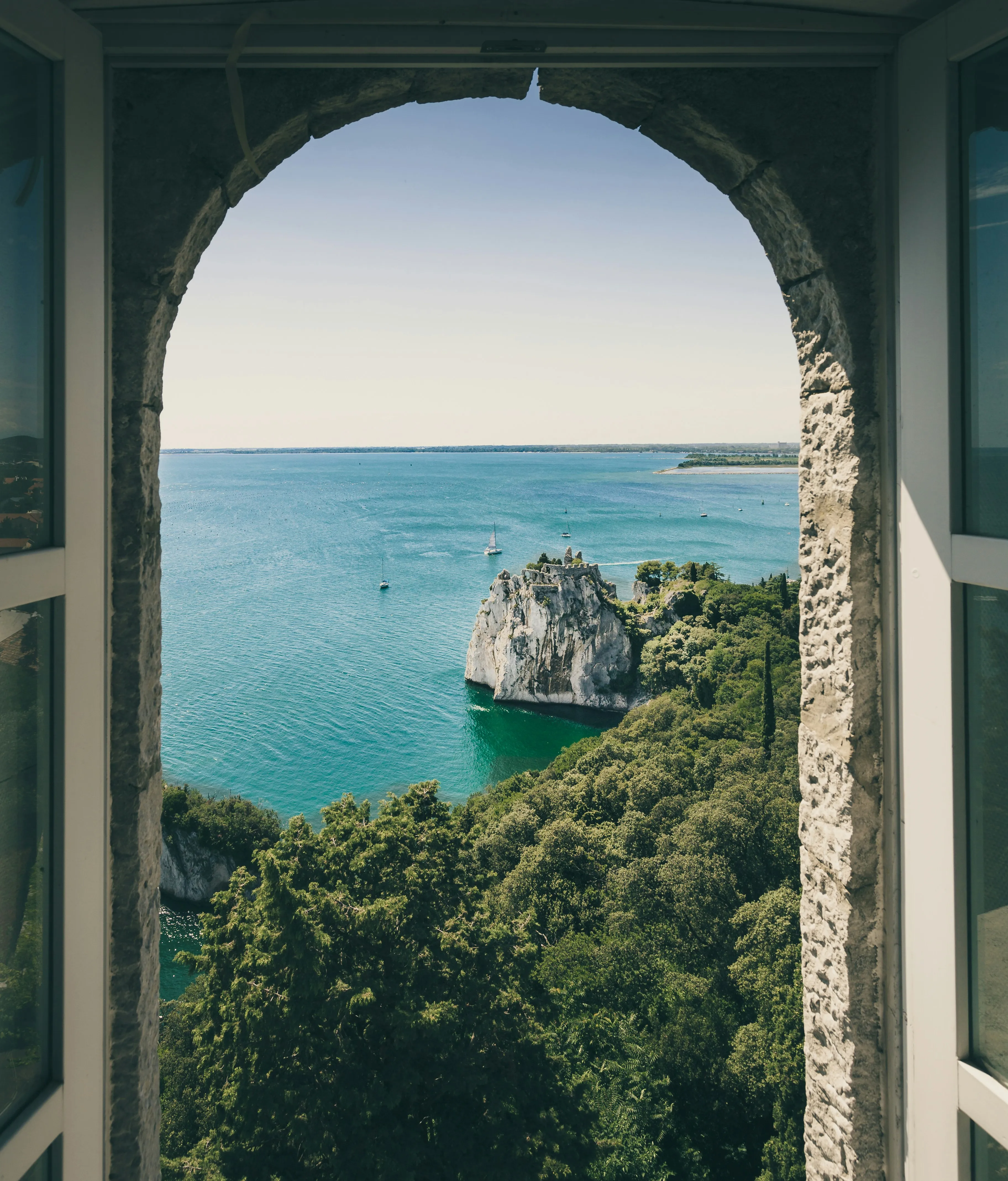 Mediterranean coast and turquoise water seen through a stone arch